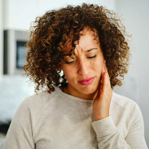 woman holding jaw in pain